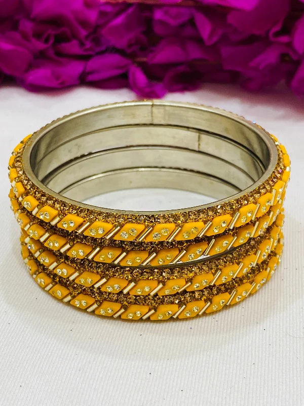 Bangles with gothic-inspired engravings for drama -Lovely Yellow Color Designed Metal Bangles With White Stone For Women